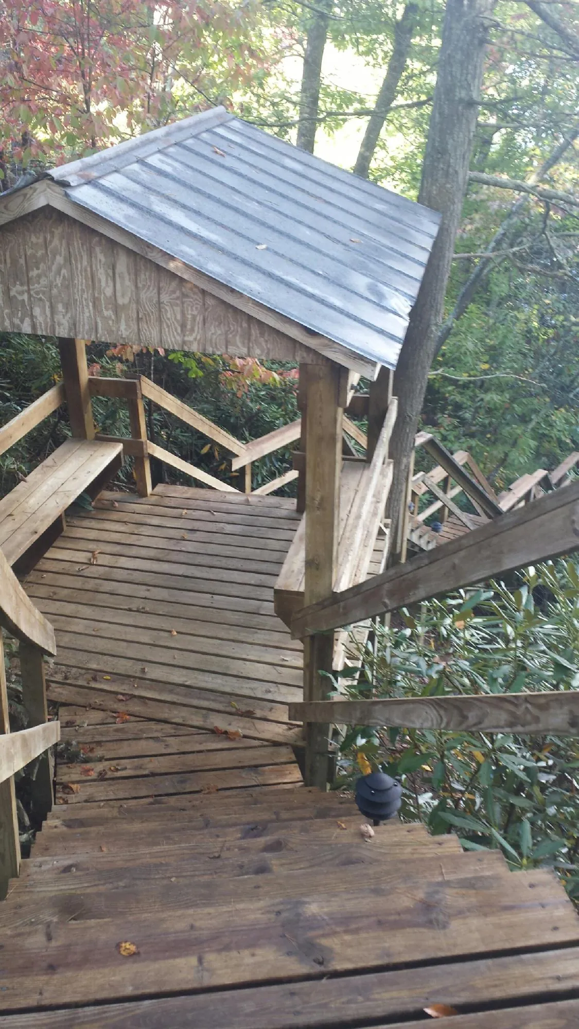 Metal roofed shelter over wooden steps on a wooded walkway — Skylight Repair & Installation work by our crew in Lakeside